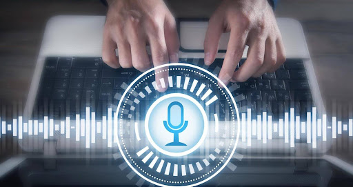 Human typing on laptop with microphone on